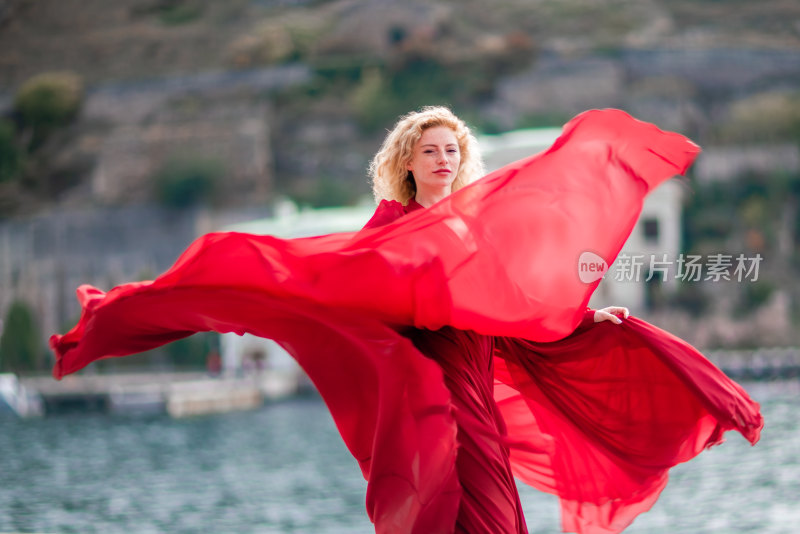 金发女子水边舞动红裙