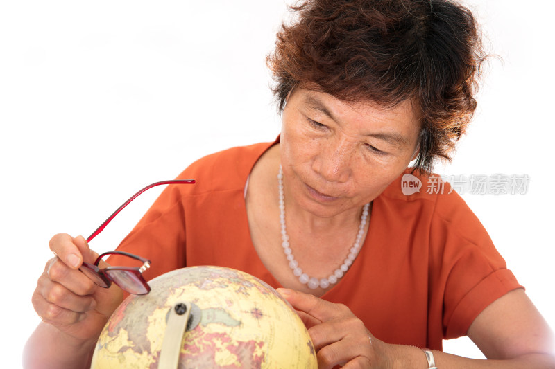 中国老太太正在查看桌子上的地球仪