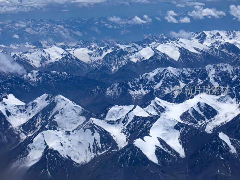 航拍视角下的新疆天山山脉雪山和蓝天白云