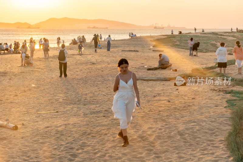 海边夕阳下的人群休闲场景