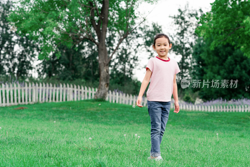 夏天独自站在草地上玩玩耍的中国女孩
