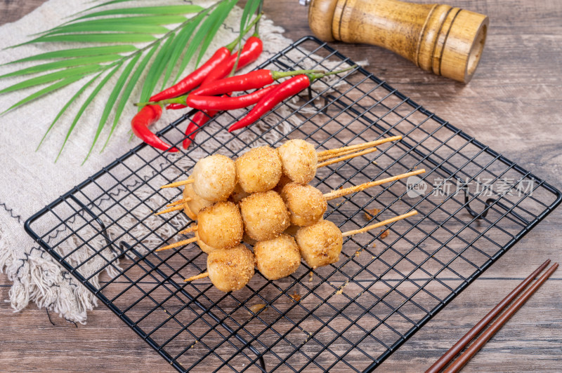 黑色网架上的美味油炸丸子串