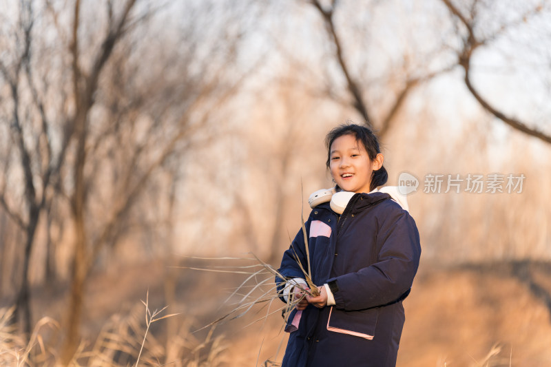 冬日暖阳在公园树林中玩耍的亚洲女孩