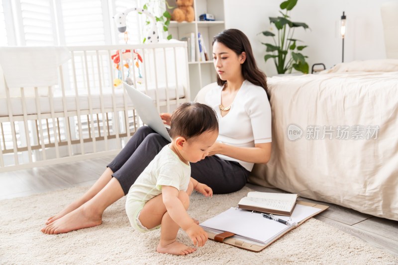 年轻妈妈带着宝宝使用电脑