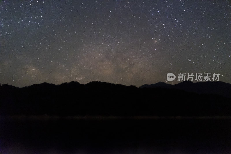 繁星密布的夜空下的山峦与湖水