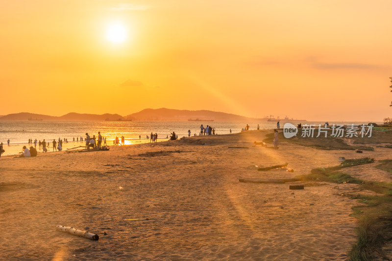 海滩夕阳下人群休闲场景