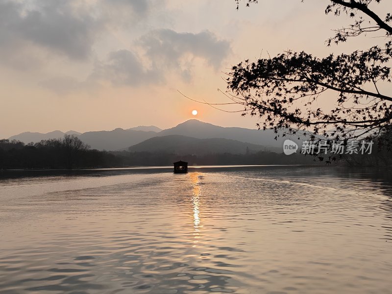 西湖湖面日出时分小船泛波的美景