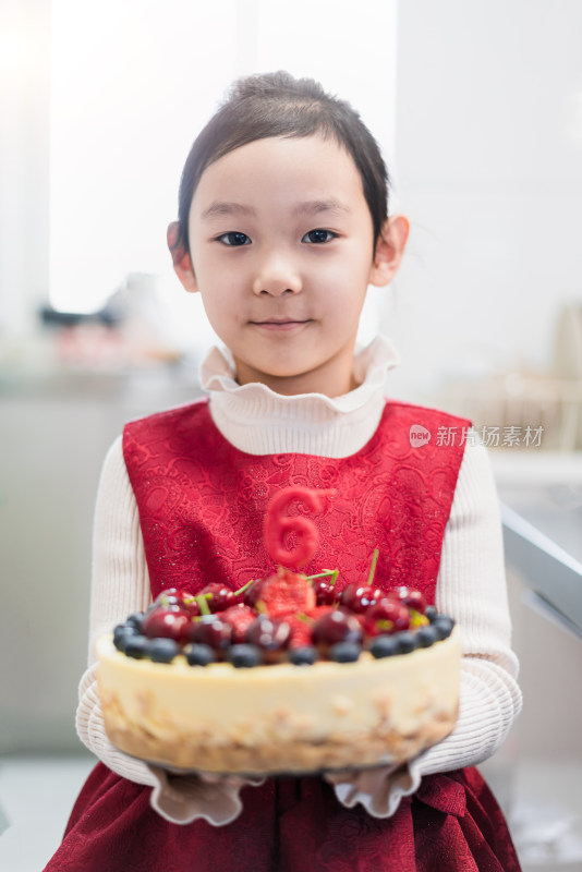 中国女孩手捧刚制作完成的生日蛋糕