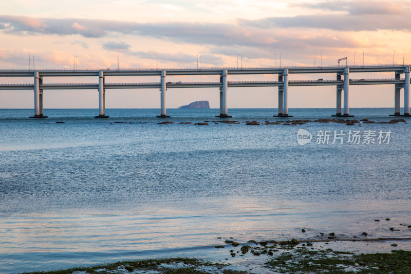 黄昏日落时的大连黑石礁公园海滩和跨海大桥