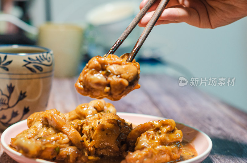 夹起一块鸡腿肉，一个中国传统花纹陶瓷水杯