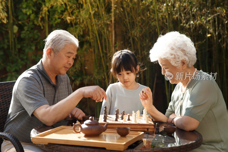 老年夫妇和孙女在院子里下棋
