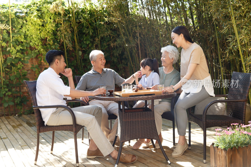 幸福家庭在院子里喝茶