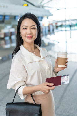 商务女士在机场拿一杯咖啡