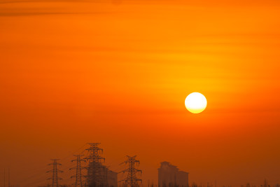 夕阳下的输电塔与建筑剪影