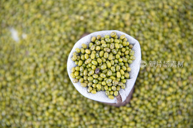 俯视一堆绿豆背景和其上一袋绿豆