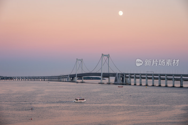 夕阳下大连星海湾大桥上空升起的月亮