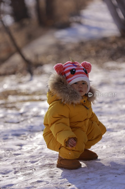 雪地中穿着厚衣的幼儿