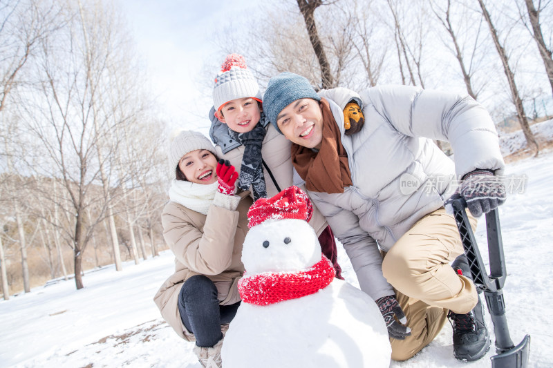 一家三口在雪地里堆雪人