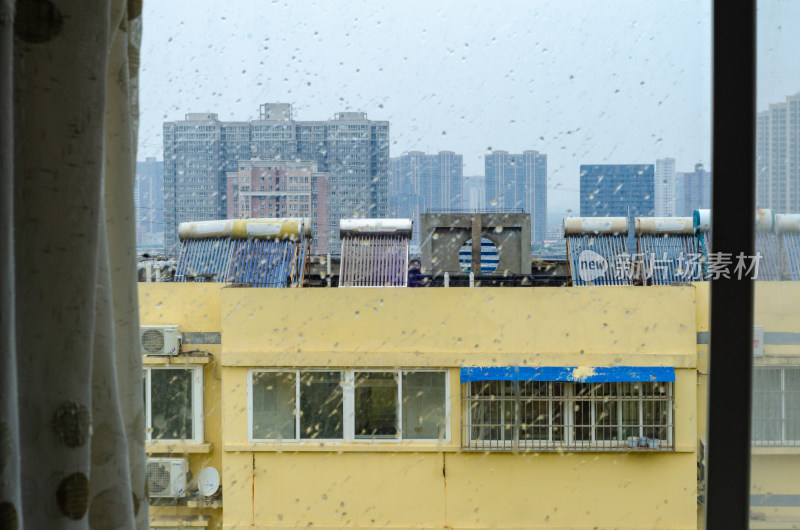 透过窗户看雨中城市建筑