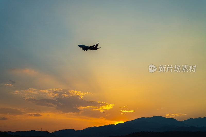 日落时飞机在天空中飞行的低角度视图