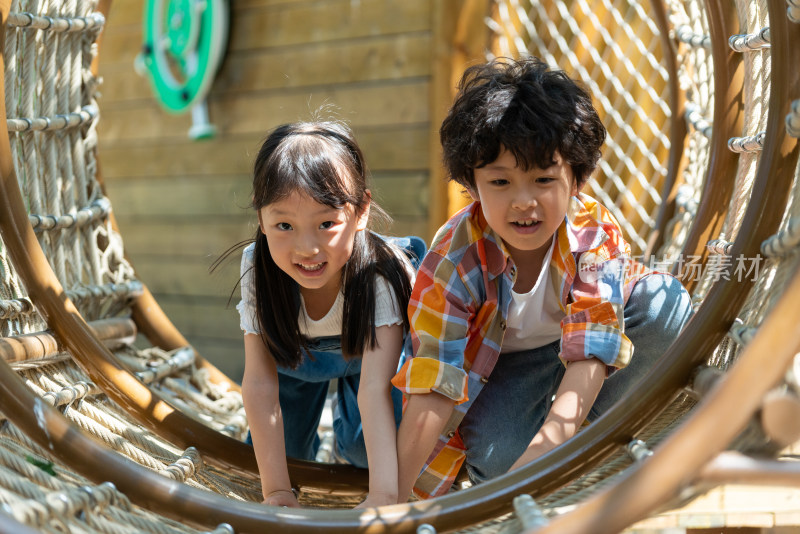 两个小孩子勇敢钻绳洞