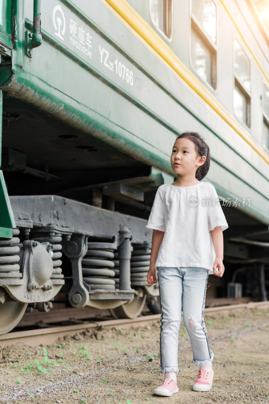中国女孩站在年代久远的绿皮火车旁