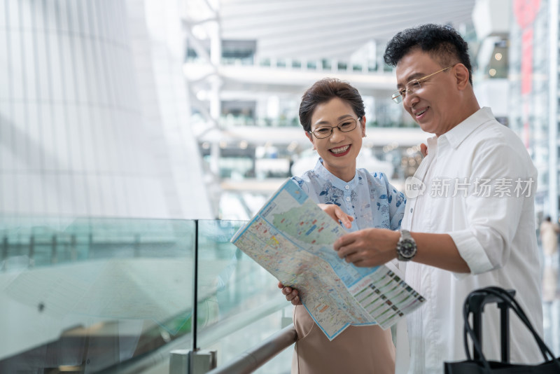 快乐的老年夫妇在机场看地图