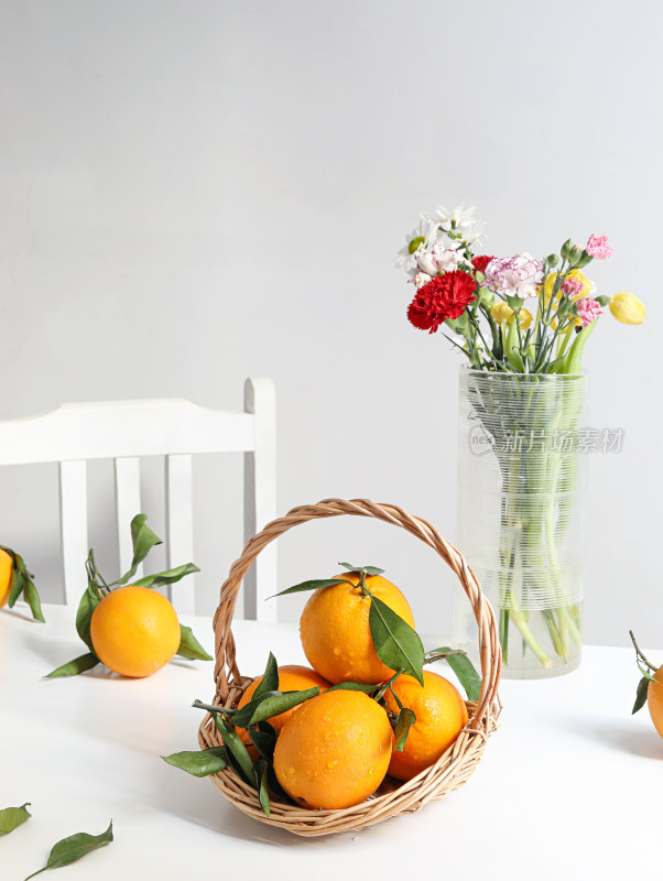 白色桌面上的新鲜水果橙子和鲜花