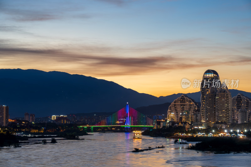 暮色下依山傍水的西双版纳多彩城市夜景