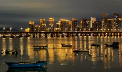 夜晚海边厦门建筑与船只景观及海上地铁