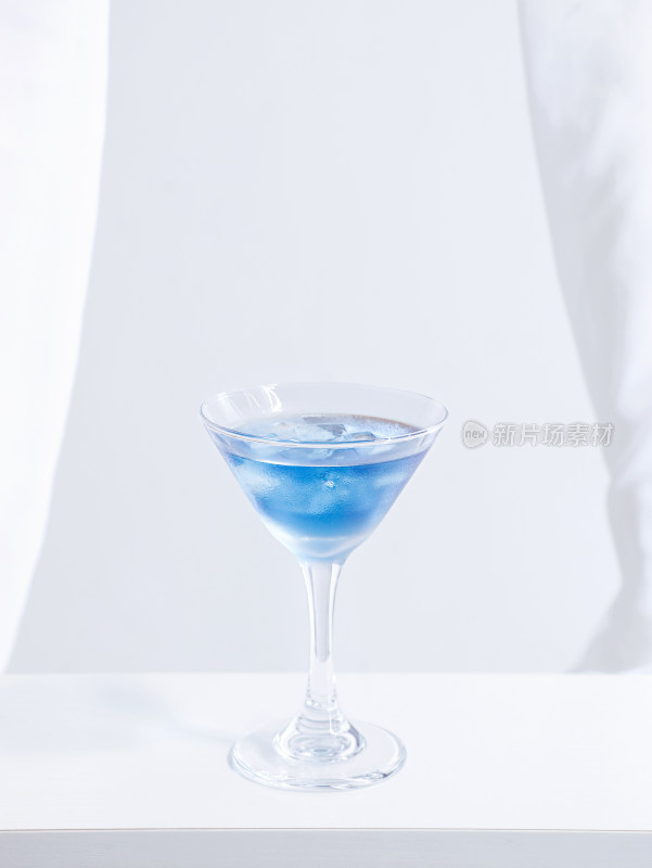 白色桌面上摆放着一杯蓝色夏日饮品