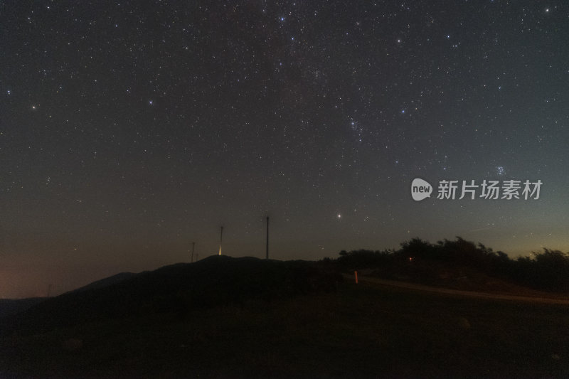 山顶上的星空夜景与风力发电机