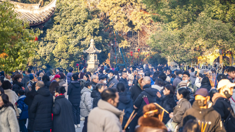 古建筑旁众多香客聚集的热闹场景