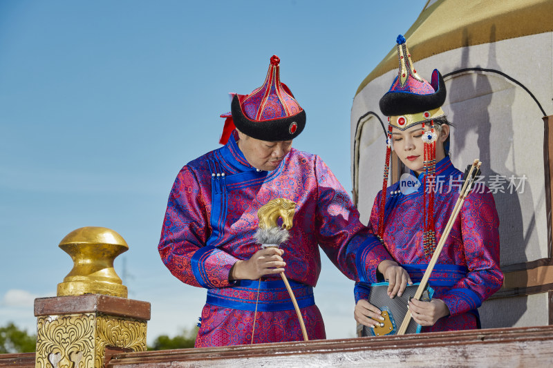 草原上蒙古包前穿蒙古族传统服饰的年轻夫妻