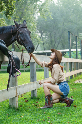 牧场内快乐个性的女孩和马玩耍