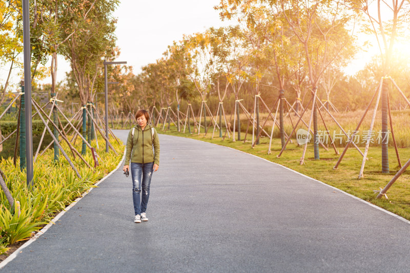 独自走在公园小路的中国籍年轻女性