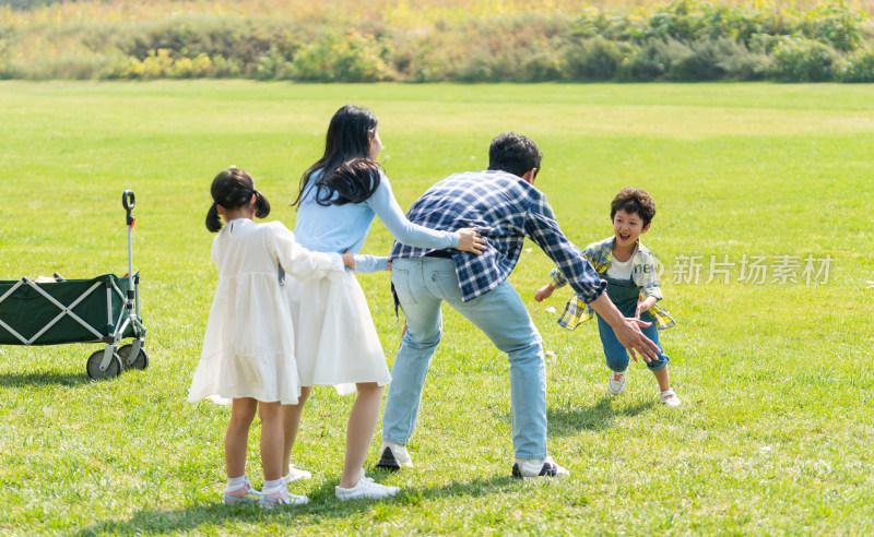 一家人在草地上开心地做游戏