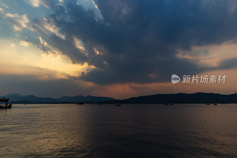 杭州西湖湖面夕阳下的山峦与云彩