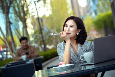 年轻女性坐在露天咖啡厅里