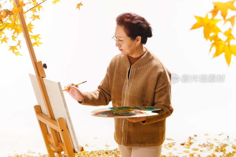中老年女人在庭院里画画