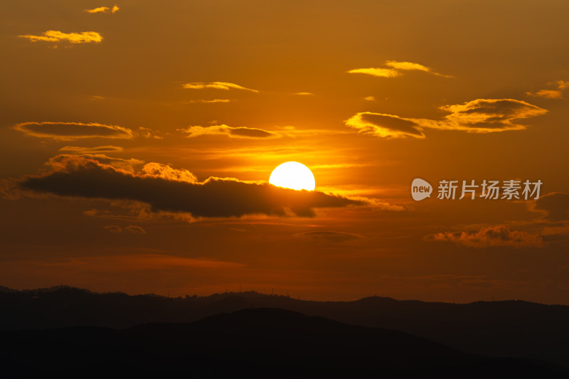 山间日落美景，夕阳映照山脉的景象